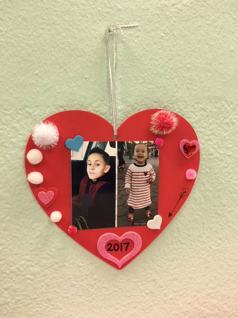 A red tactile valentine with two children pictured in the center